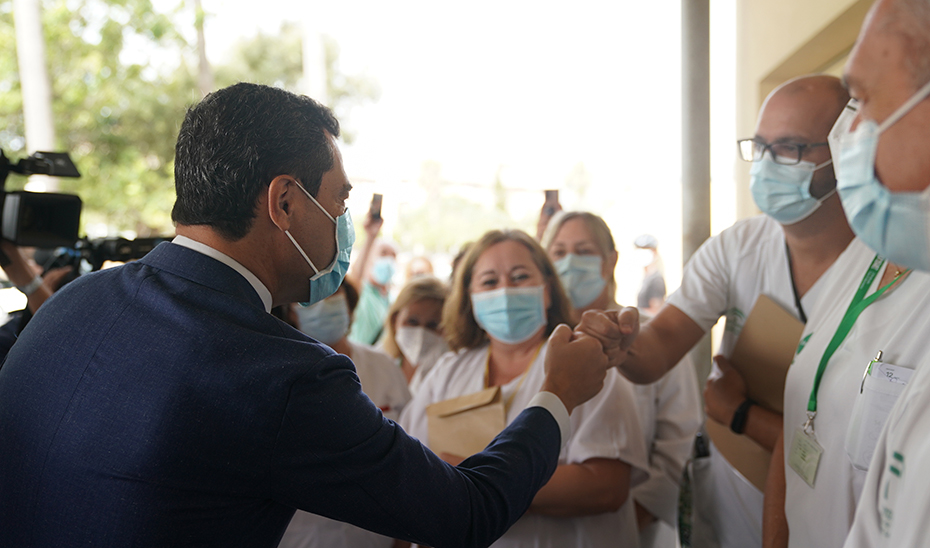 Juanma Moreno saluda a los profesionales sanitarios a su llegada al Hospital Punta de Europa.