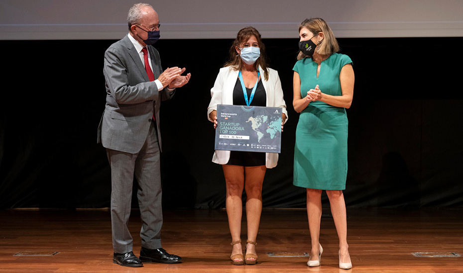 La consejera de Empleo, Rocío Blanco, aplaude a la ganadora de la Copa Mundial de Emprendimiento junto al alcalde de Málaga.