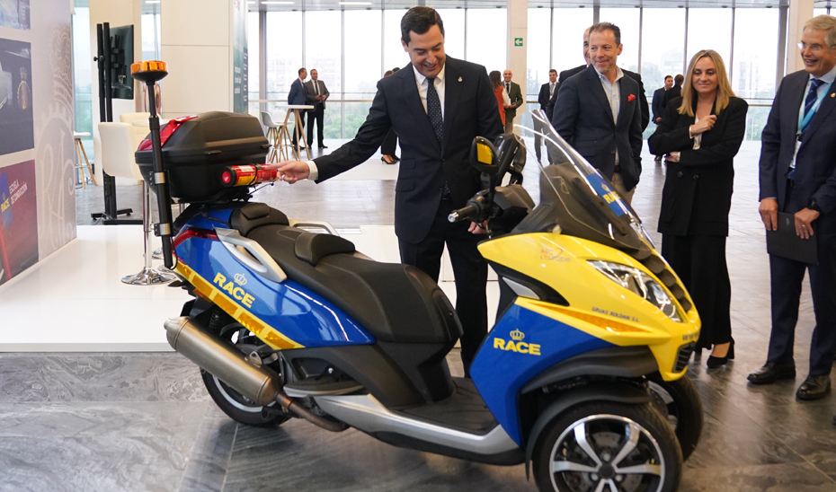 Juanma Moreno con un vehículo sostenible en la inauguración del MOW Fórum Andalucía 2022.