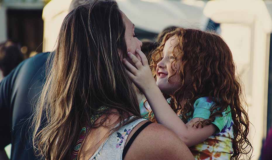 Una mujer abraza a una niña.