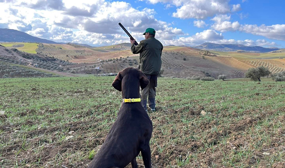 Un cazador junto a su perro. 