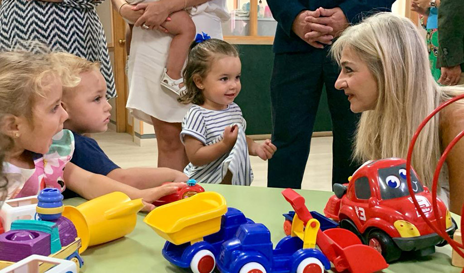 Patricia del Pozo saluda a unas niñas en su visita a la Escuela Amapola de Carmona (Sevilla) por el arranque del nuevo curso de Educación Infantil.