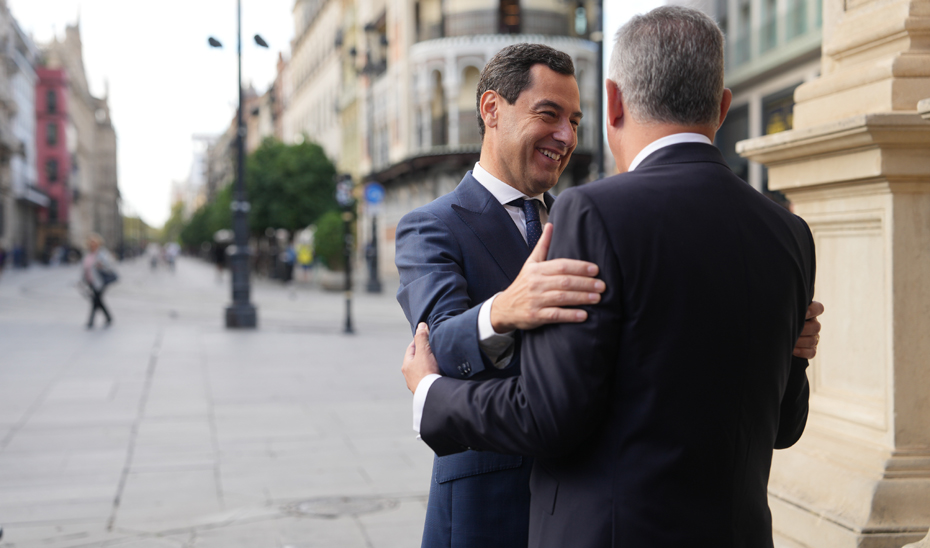 Juanma Moreno saluda al alcalde de Sevilla, José Luis Sanz, a su llegada al Ayuntamiento.