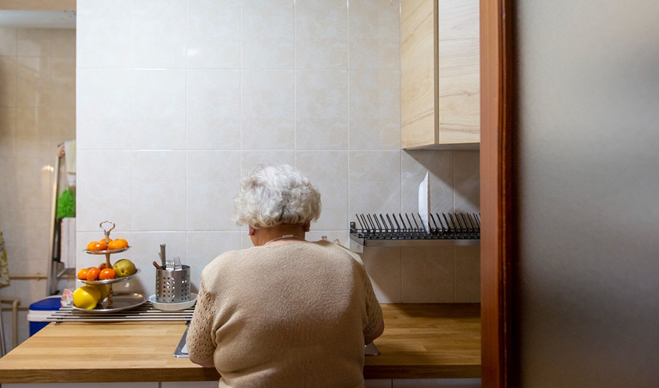 
			      Una mujer, en la cocina de su vivienda.			    
			  