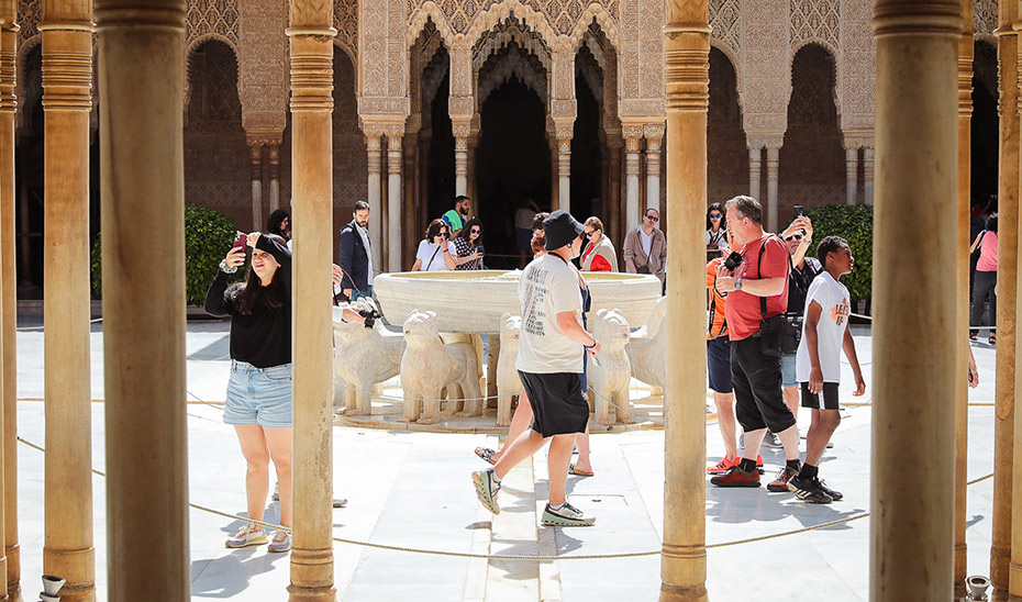 Un grupo de turistas visita el Patio de los Leones de la Alhambra de Granada.