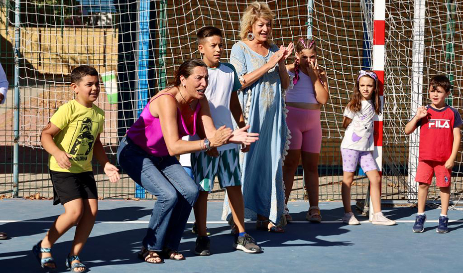 La consejera de Inclusión Social, Juventud, Familias e Igualdad, Loles López, durante la visita a la escuela de verano del Distrito V en Huelva, acompañada por la alcaldesa de la ciudad, Pilar Miranda.