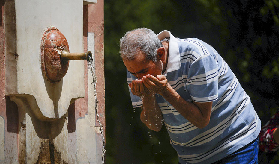 Un hombre se refresca en una fuente en Córdoba por el calor (EFE).