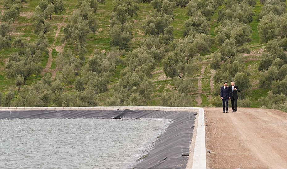 Juanma Moreno pasea junto a la balsa que acoge la planta fotovoltaica flotante, acompañado por el presidente del Grupo Castillo de Canena, Luis Vañó.