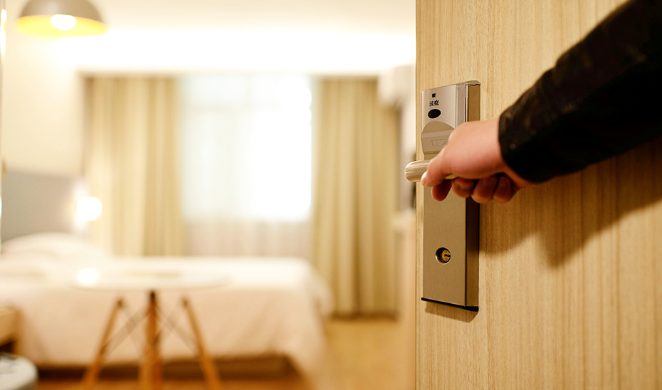 
			      Imagen de una usuaria abriendo la puerta de su habitación de hotel			    
			  