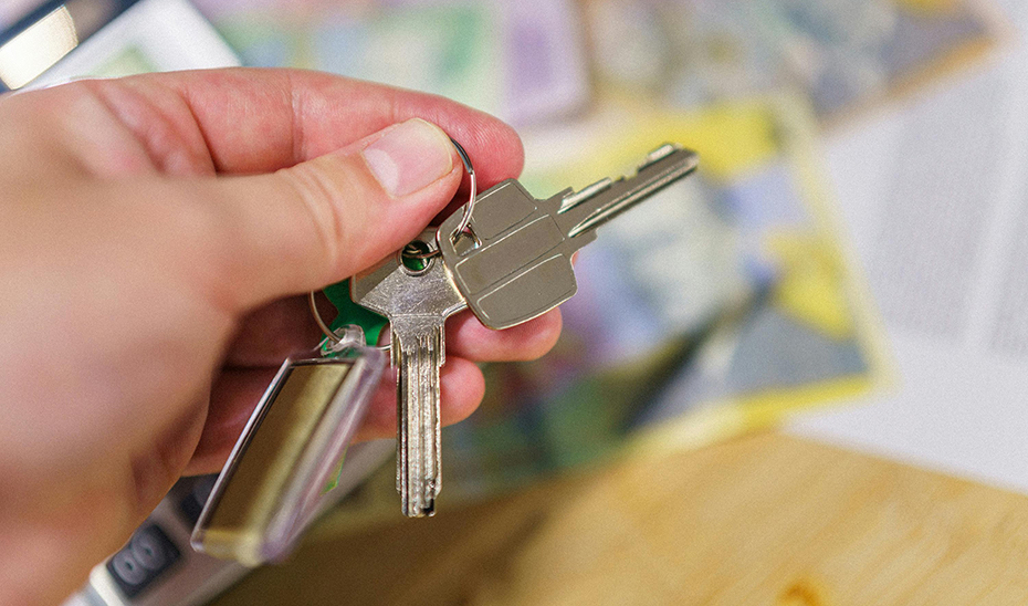 Una persona sostiene las llaves de una vivienda.