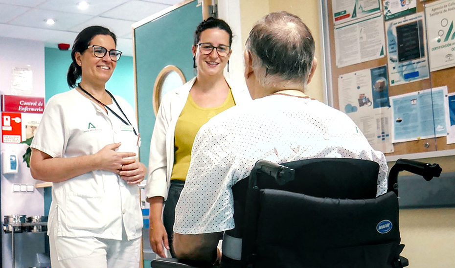 Dos profesionales sanitarias junto a un paciente con daño cerebral adquirido.