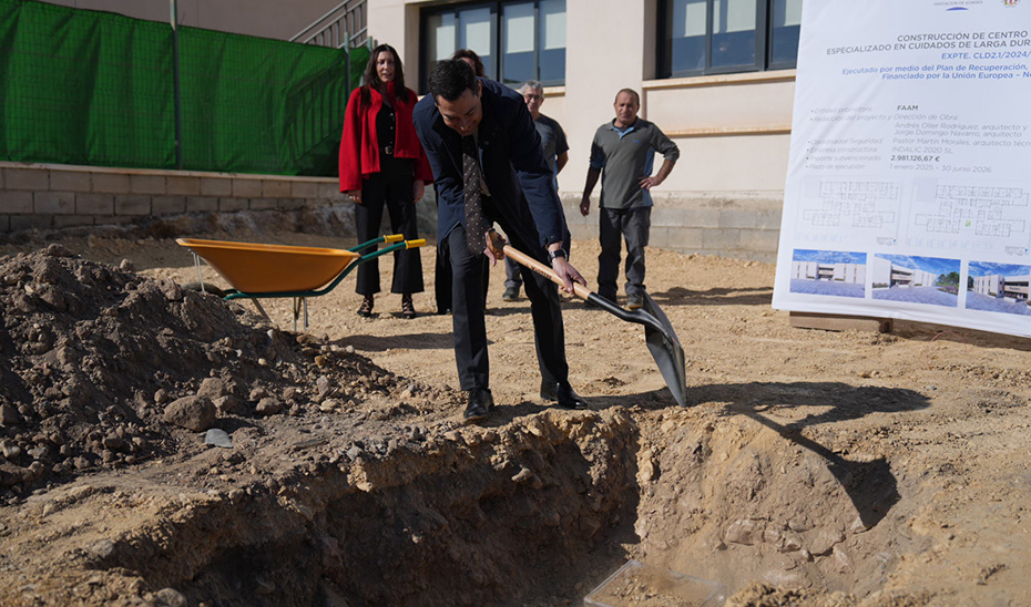 Juanma Moreno echa una palada de tierra durante el acto de colocación de la pirmera piedra del Centro Residencial 'Vivir como en casa' de Almería.