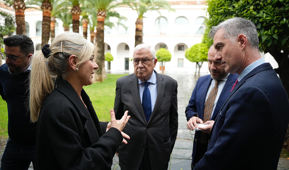 
			      Patricia del Pozo, junto al maestro Abel Moreno y representantes de bandas de música en el Parlamento Andaluz.			    
			  