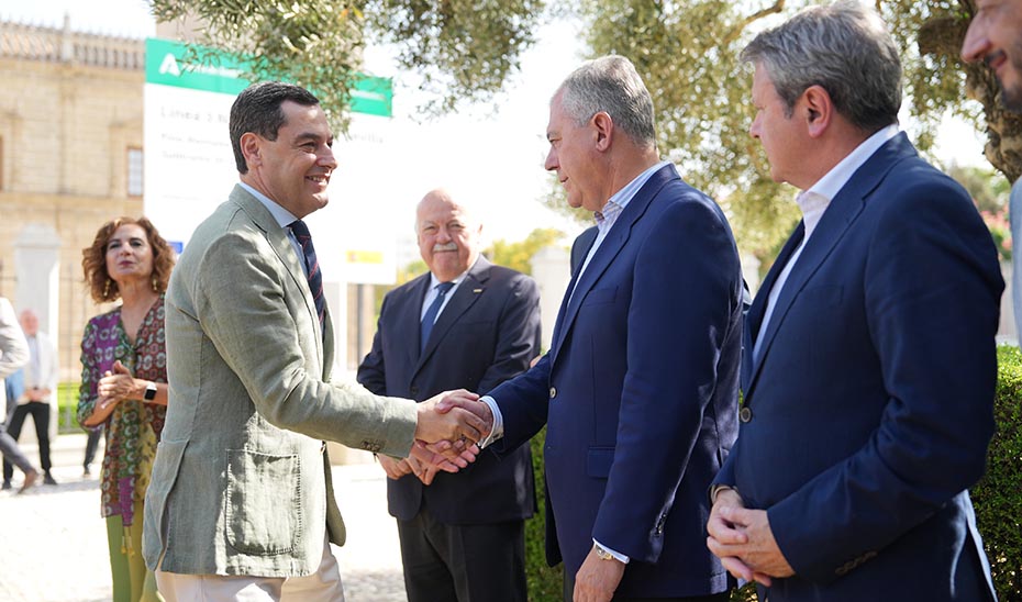 Juanma Moreno saluda al alcalde de Sevilla, José Luis Sanz, en presencia de otras autoridades asistentes al acto.