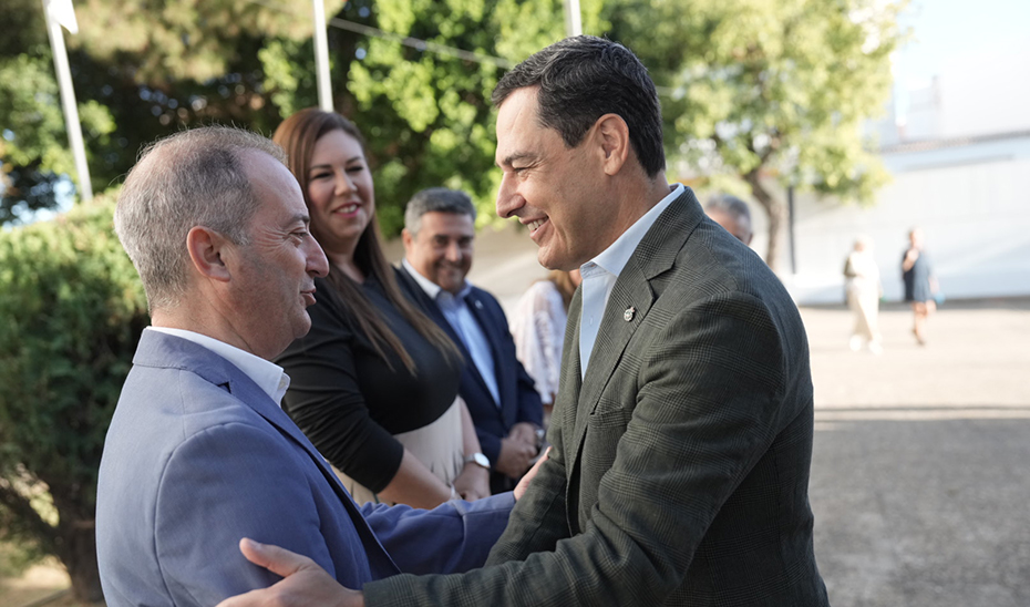 Juanma Moreno saluda a Sergio Rosado, director del CEIP Los Llanos.