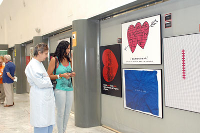 Paciente y usuaria observan los carteles de la exposición