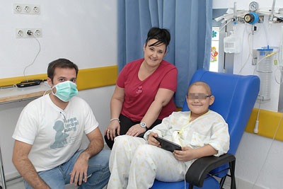 Uno de los niños ingresados en el hospital sonríe con su nueva tablet