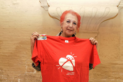 Rosa María Calaf posa con el carné de donante y la camiseta roja de la donación de órganos