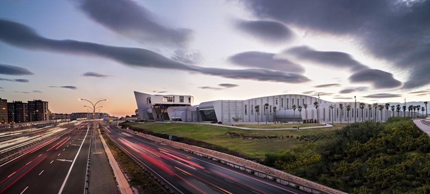 Carretera al atardecer con edificio de fondo