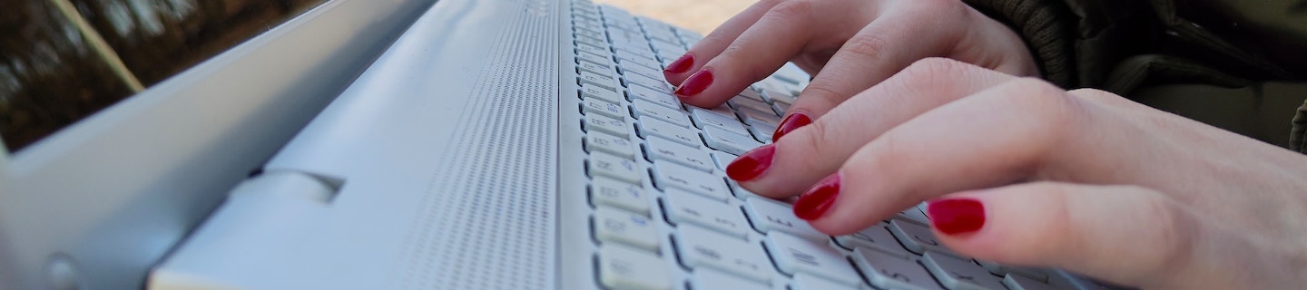 Manos de mujer sobre teclado de ordenador