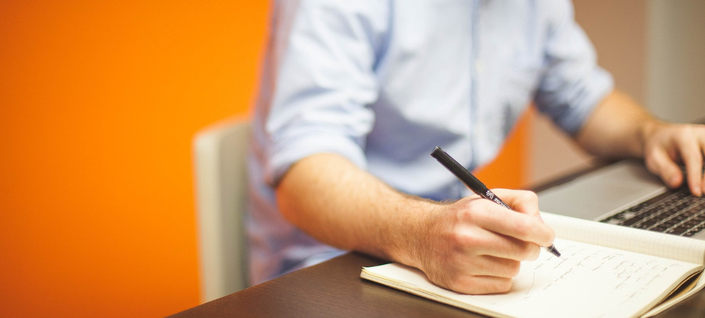 Una persona estudia y coge notas en un cuaderno