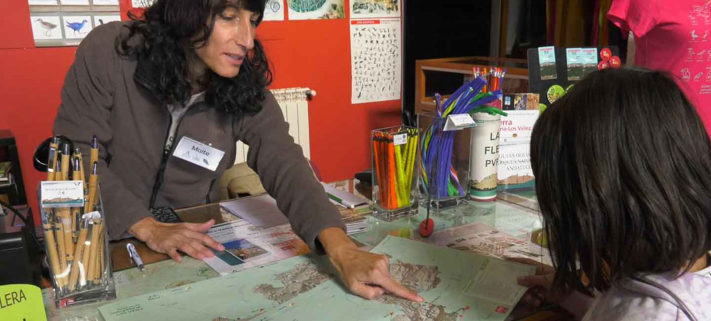 Una técnico de Amaya muestra a otra, en una mesa, diversa documentación