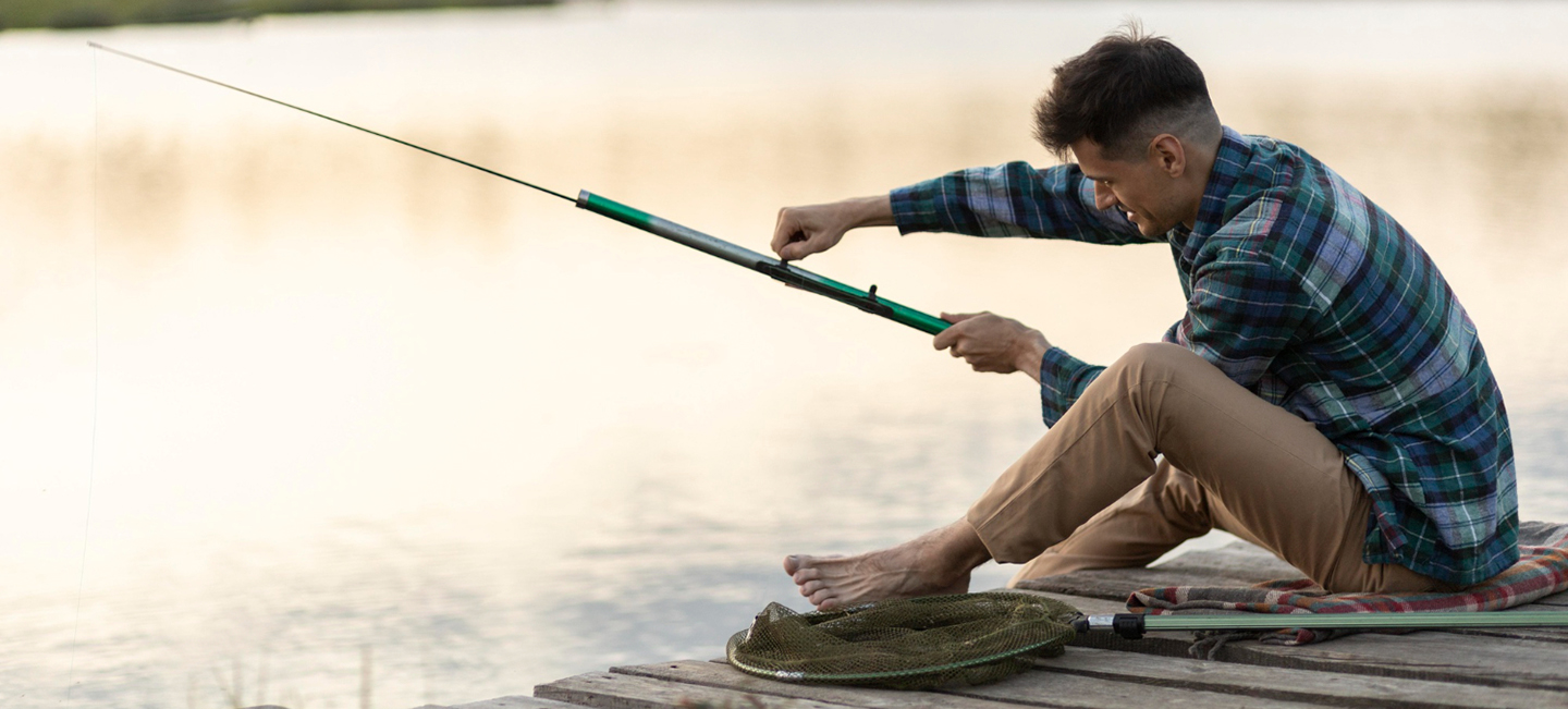 Una persona se dispone a pescar desde un pequeño embarcadero de madera