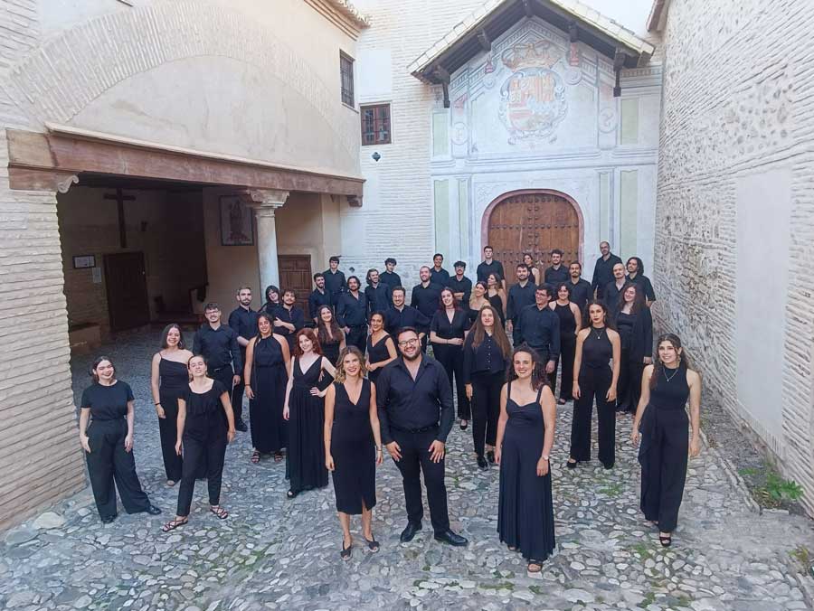 Integrantes de un coro posan en el patio de un edificio histórico